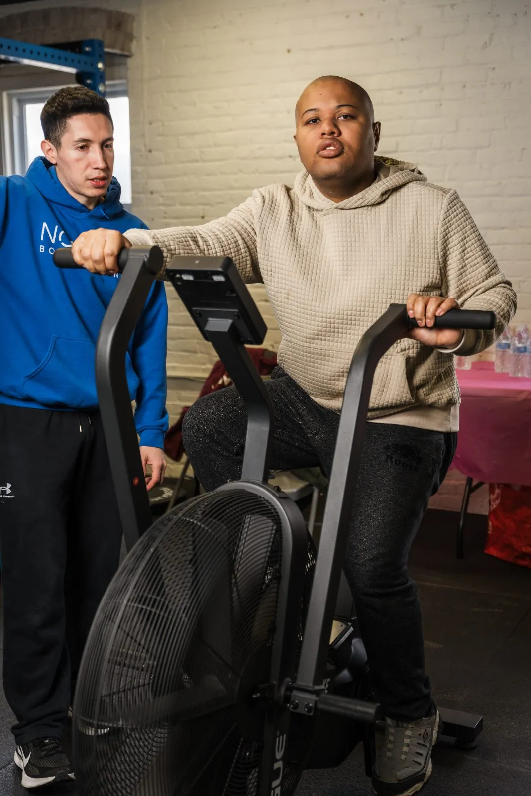 A coach guiding an athlete on the air bike