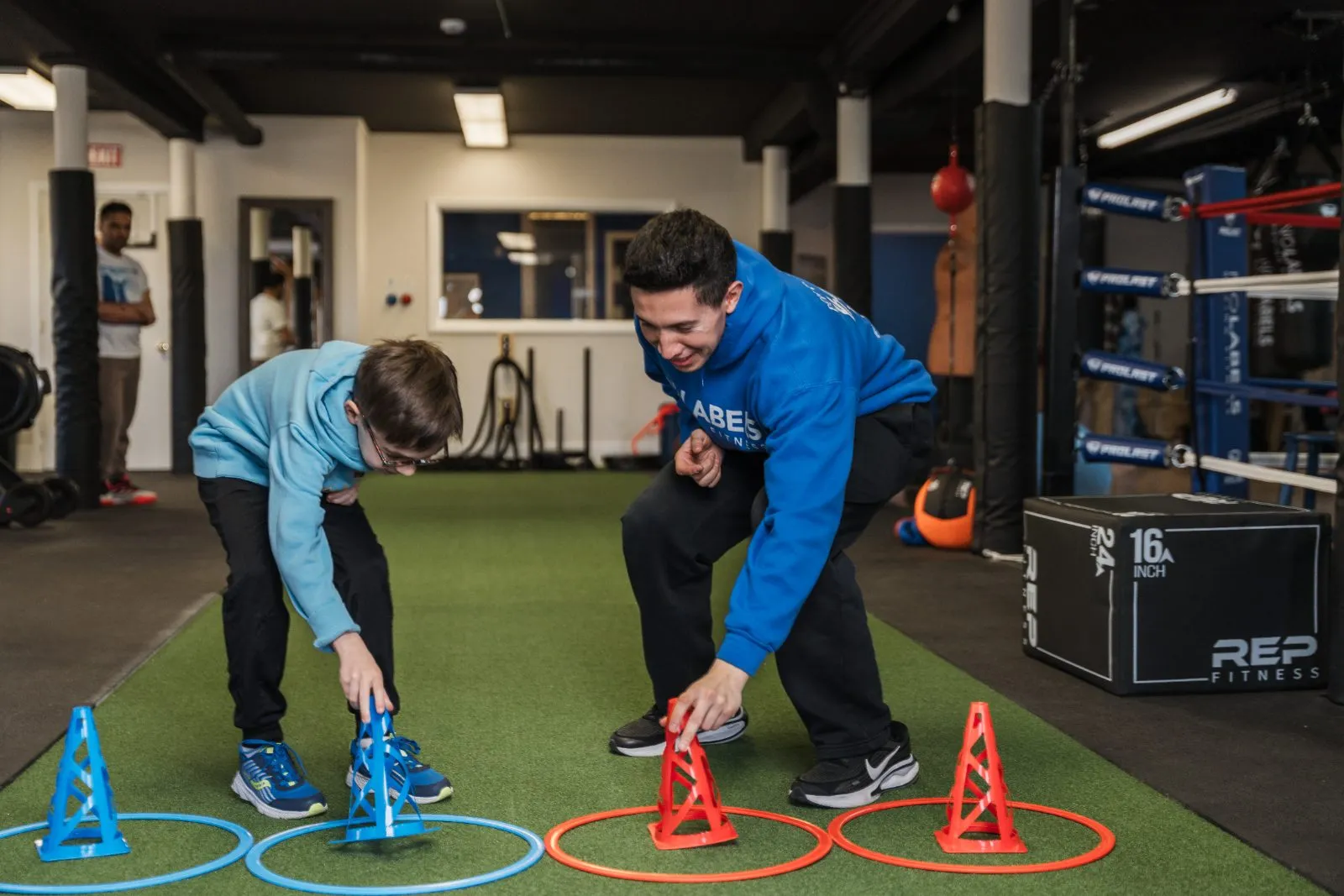 A coach and young athlete doing a cone drill