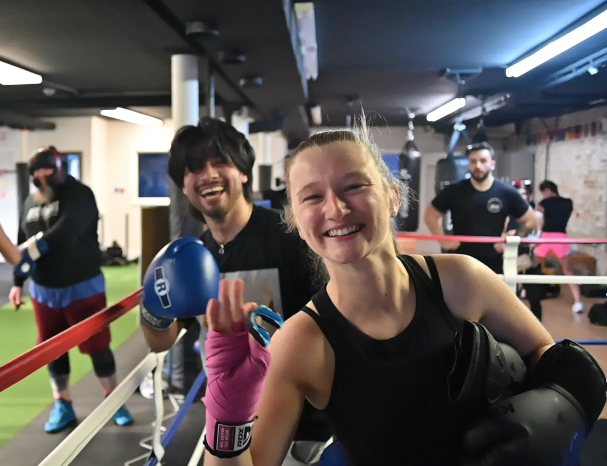 Members smiling at the ring during a boxing fitness class at No Labels Boxing Fitness in Boonton, NJ